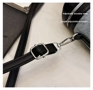 Detail of adjustable black leather shoulder strap with silver metal buckle and swivel hook