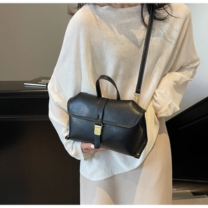 Detail of vintage black handbag with white contrast stitching and gold buckle
