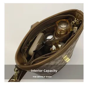 Detail showing internal capacity of the brown bucket bag with central zip compartment