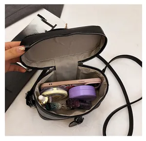 Interior view of black vanity bag showing space for phone, lipstick and compact