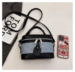 Top view of two-tone denim and black leather box bag showing compact interior capacity