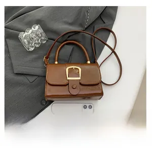 Vista dall'alto di una borsa vintage marrone scuro con fibbia dorata e tracolla lunga