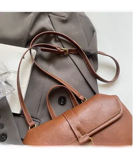 Close-up of adjustable brown leather shoulder strap with white contrast stitching