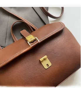 Detailed macro view of caramel leather bag with contrast stitching and golden hardware
