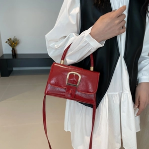 Borsa a mano retrò rossa con fibbia dorata e tracolla indossata con un outfit
