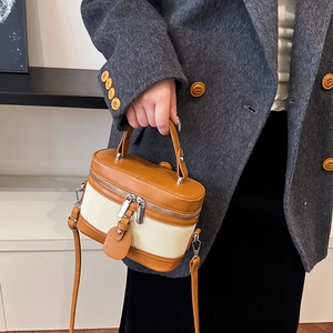 Retro vintage box handbag with brown leather and canvas panels worn with a grey blazer