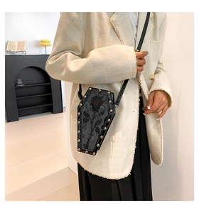 Gothic coffin-shaped crossbody bag with rose relief and silver studs on model