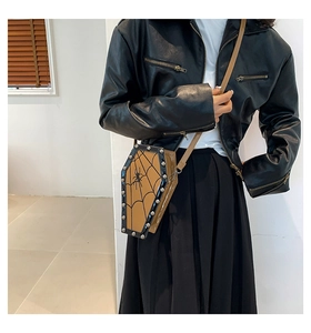 Gothic coffin-shaped crossbody bag with spider web patterns and silver rivets shown on model