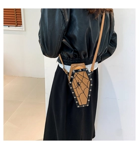 Detail view of coffin-shaped crossbody bag with spider web pattern and silver rivets