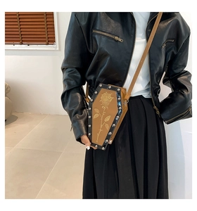 Detail of coffin-shaped crossbody bag with rose pattern and silver rivet trim