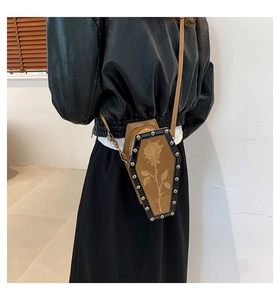 Gothic coffin-shaped crossbody bag featuring rose print and silver studs on the model