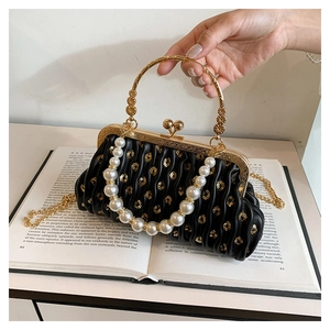 Detail of pleated black leather bag with pearl trim and vintage gold floral kiss-lock closure