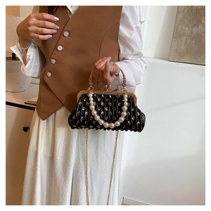 Detail of sequin pleated evening bag with pearl handle and golden chain strap