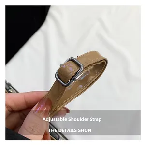 Close-up of adjustable khaki patent leather shoulder strap with silver metal buckle detail