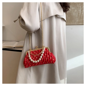 Detail of red pleated leather clutch with pearl handle and vintage gold ball clasp