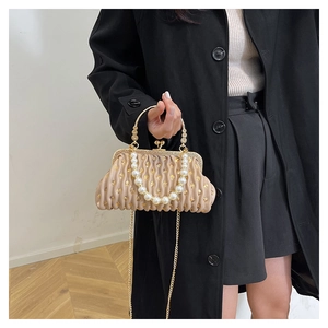 Detail of champagne pleated evening bag with sequins, pearl handle and gold chain