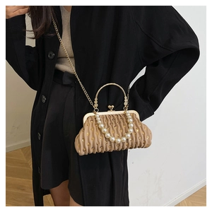 Detail of sequined pleated shell bag with pearl handle and metal chain strap