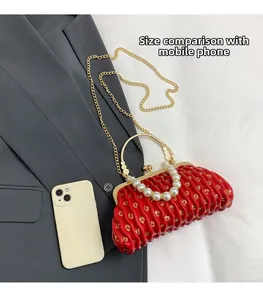 Detail of red ruched clutch with pearl handle and sequins compared to a smartphone