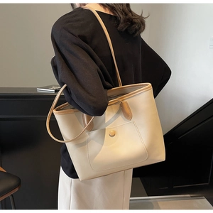 Detail view of large cream tote bag with contrast edges and snap pocket for daily commuting