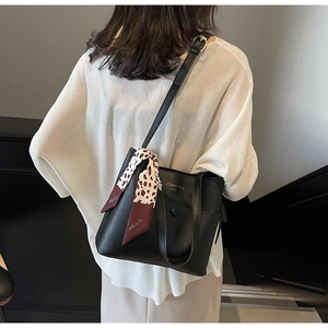 Details der schwarzen Leder-Beuteltasche mit Leoparden-Schal und Classic Bag Prägung