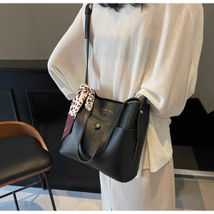 Minimale schwarze Beuteltasche mit Knopfverschluss und Akzent durch Leoparden-Seidenschal