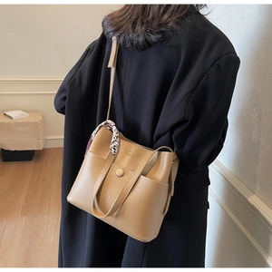 Khaki Leder-Beuteltasche mit Leoparden-Tuch und Fronttasche am Model in Detailansicht