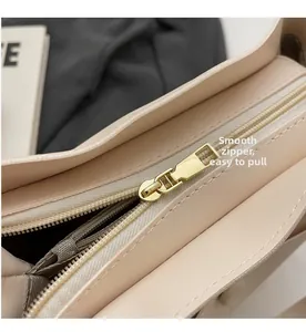 Detail des glatten goldenen Metallreißverschlusses und der beigen Textur der Tasche