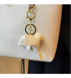 Close-up of elephant PU leather charm with gold swivel clasp on a shoulder bag