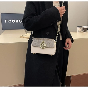 Dettaglio borsa beige a tracolla con patta glitter, fibbia a corona e catena dorata