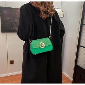 Dettaglio borsa box verde con paillettes, chiusura a corona dorata e catenina