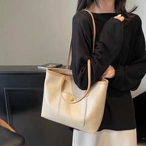 Minimalist cream tote bag with brown handles and front pocket for daily commute use
