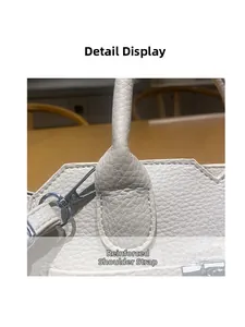 Detailed close-up of reinforced handle stitching on a cream lychee leather handbag