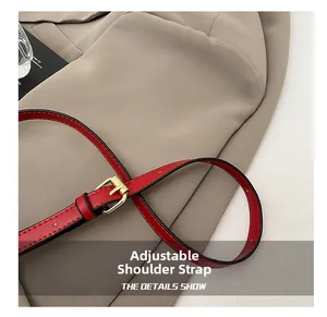 Détail de la bandoulière réglable en cuir rouge avec boucle en métal doré de qualité