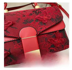 Détail du sac à main rouge avec broderie papillon 3D et ornements en métal doré chic