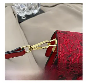 Détail du crochet en métal doré et broderie florale en dentelle rouge sur le sac