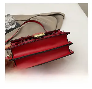 Détail du fond résistant en cuir rouge et du fermoir carré doré du sac à main