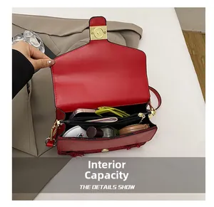 Capacité interne du sac en cuir rouge avec poche zippée et détails en métal doré