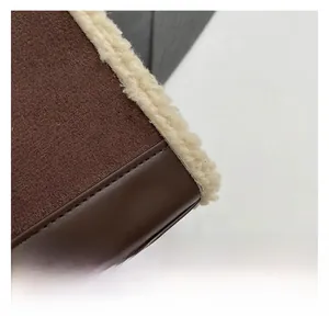 Detail der dunkelbraunen Wildleder-Nähte mit weißer Lammwolle auf der Umhängetasche
