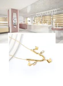 Detailansicht einer goldenen Schmetterlingshalskette mit Kristallen und Perlenkette