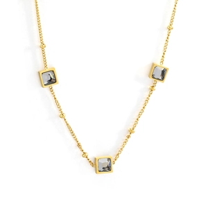 Golden bead necklace featuring three square gray crystal pendants on a white background
