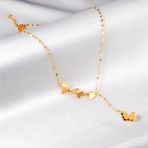 Goldene Schmetterlings-Y-Halskette mit Anhängern auf elegantem weißem Seidenhintergrund