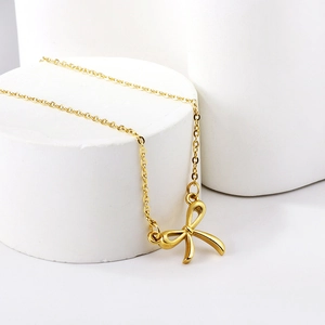 Minimalist 18K gold plated stainless steel bow necklace on a white display stand