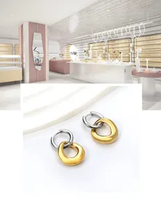Gros plan détaillé de boucles d'oreilles bicolores avec pendentifs gouttes d'or mat