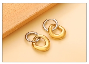 Détail de boucles d'oreilles bicolores or et argent avec texture mate et boucle