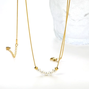 Detail of gold snake chain necklace featuring five white pearls and lobster clasp