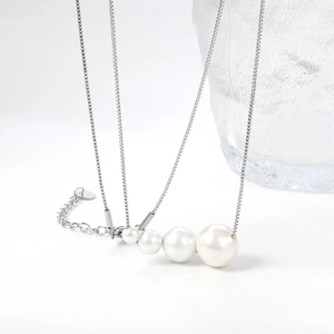 Minimalist silver necklace with four gradient sized white pearls on a fine chain
