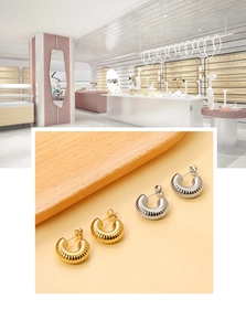 Détails macro de boucles d'oreilles en C dorées et argentées avec texture nervurée métal