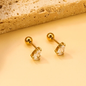 Gold pear-shaped stud earrings with clear crystals on natural stone display