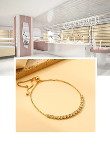 Détail du bracelet doré avec pierres en zircone et fermoir à boule coulissante réglable