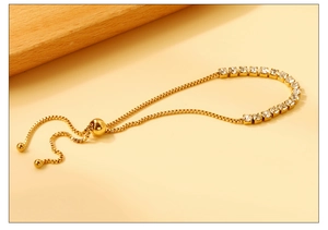 Détail d'un bracelet tennis doré avec zircons carrés et fermoir à glissière réglable